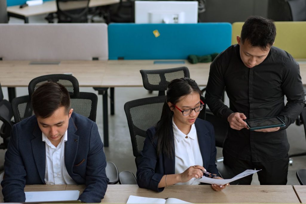A professional team collaborating in a modern office setting, focusing on documents and technology.
